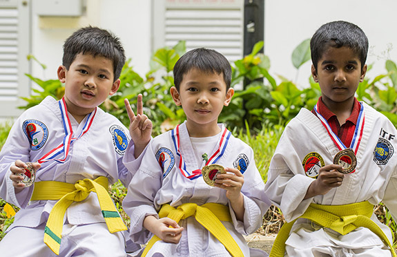 Atlit beladiri anak-anak TaekwonDo ITF Indonesia Memamerkan Mendali dengan Atlit Singapore dalam Kejuaraan ITF Singapore 2018