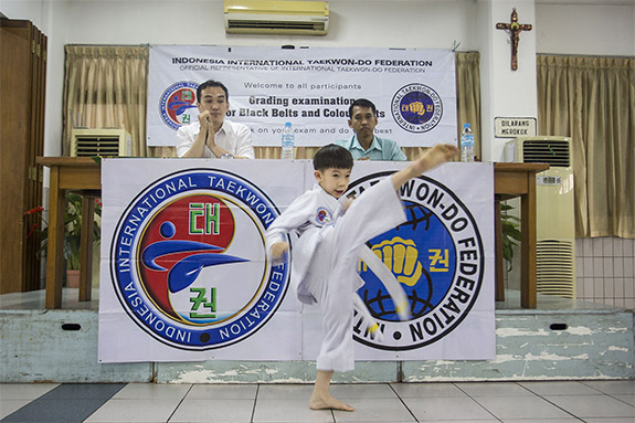 Seorang anak tengah melakukan teknik di hadapan penguji sebagai hasil dari latihan dengan pelatih beladiri TaekwonDo ITF.