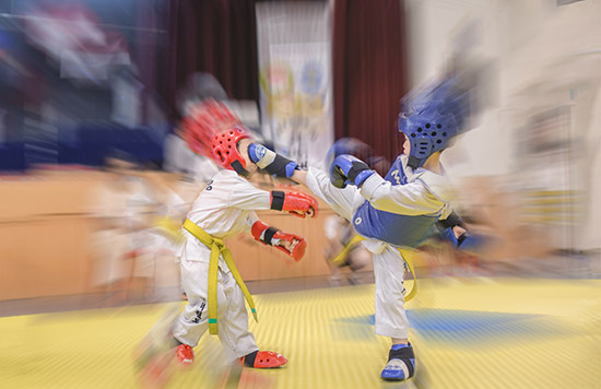 Pelatih melakukan inspeksi atas Sparring yang dilakukan anak kecil praktisi beladiri TaekwonDo.